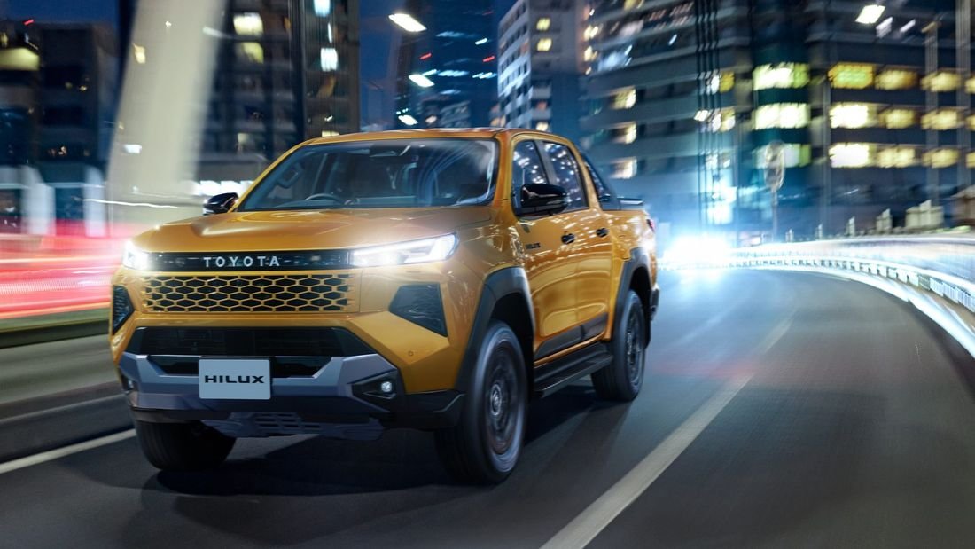 New Toyota Hilux driving through a city at night